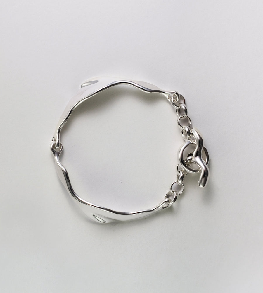 Silver bracelet on a light gray background
