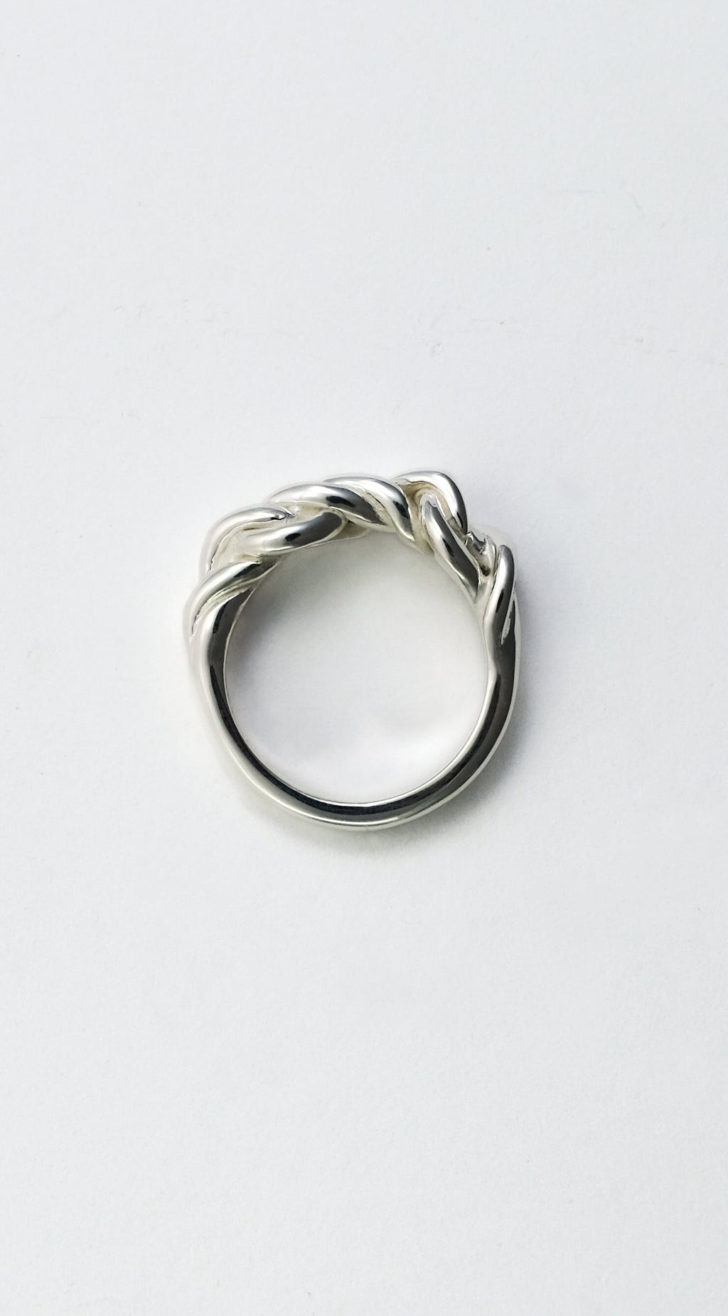 Silver ring with a twisted design on a white background