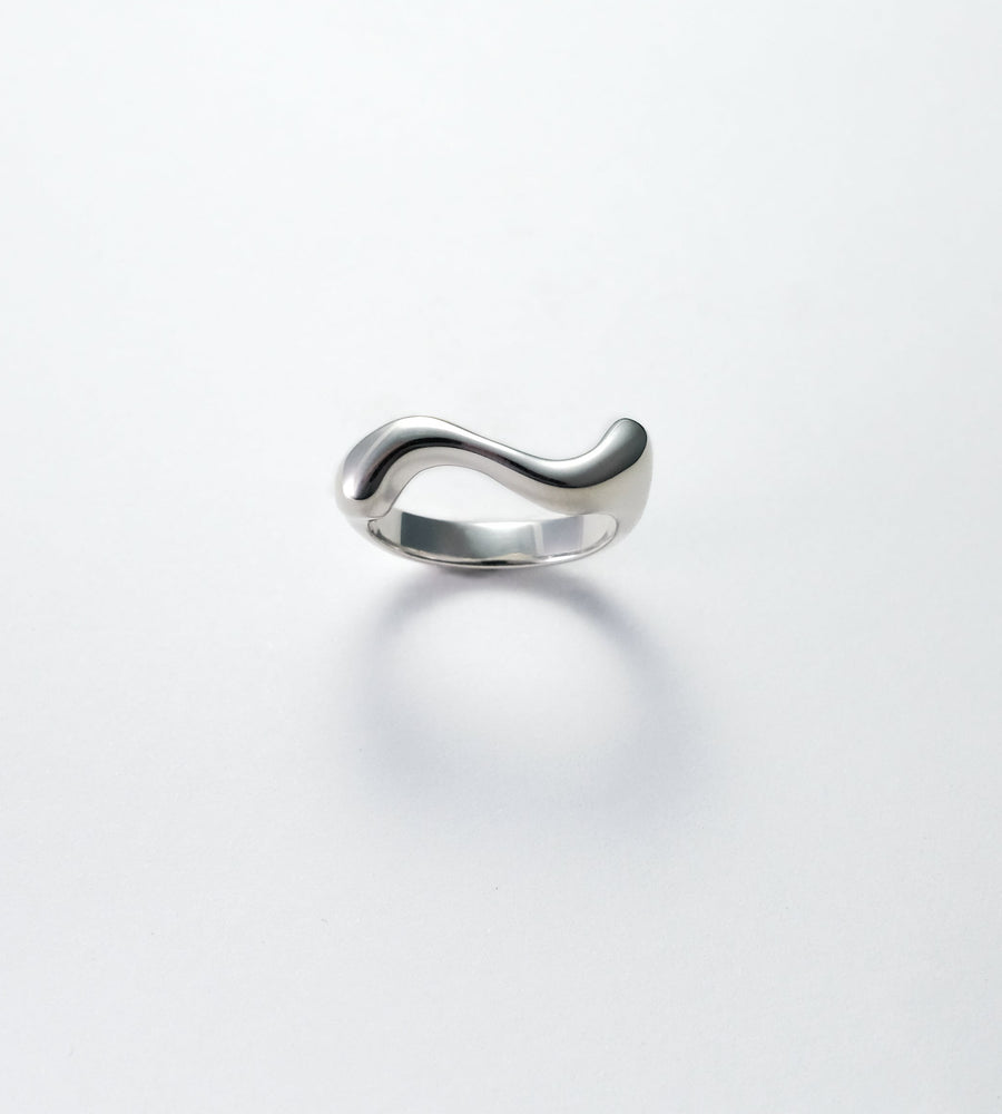 Silver ring with a wavy design on a white background