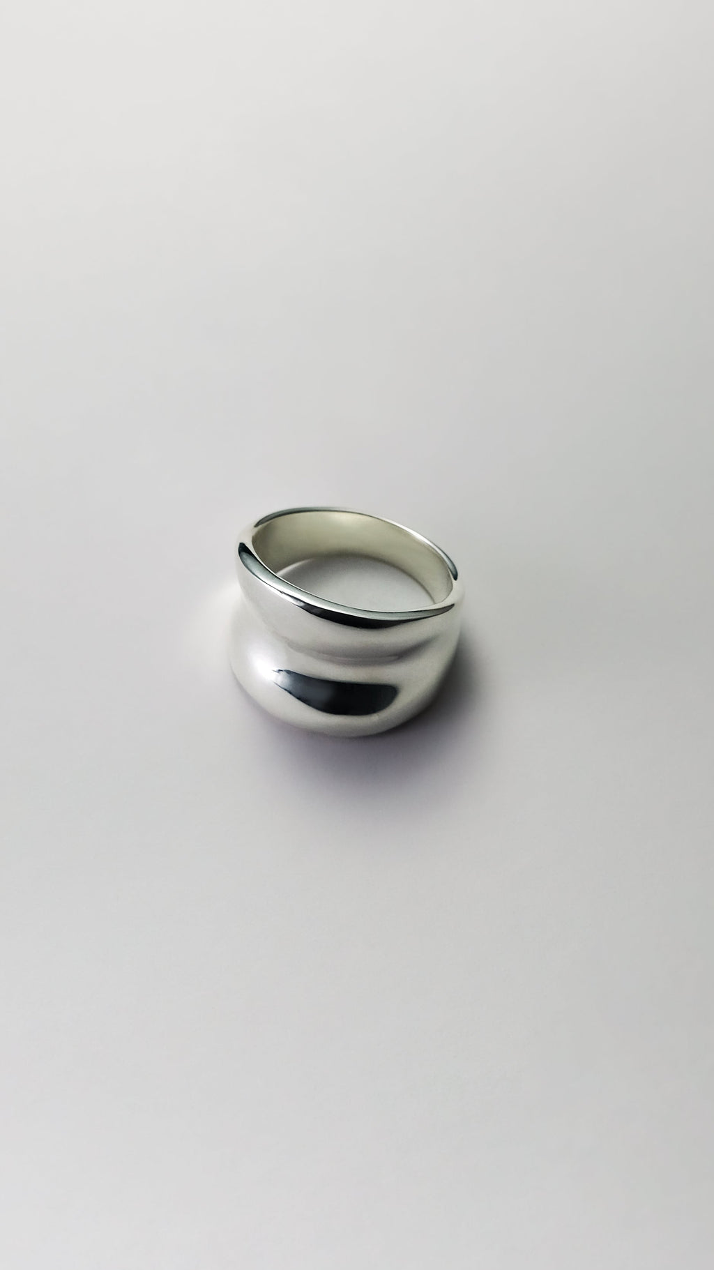Silver ring on a light gray background