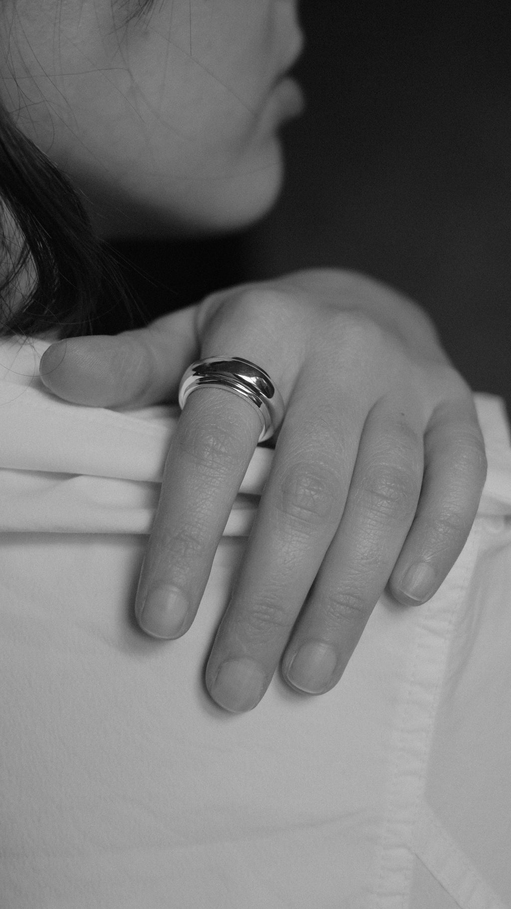 Close-up of a hand with two rings on a blurred background
