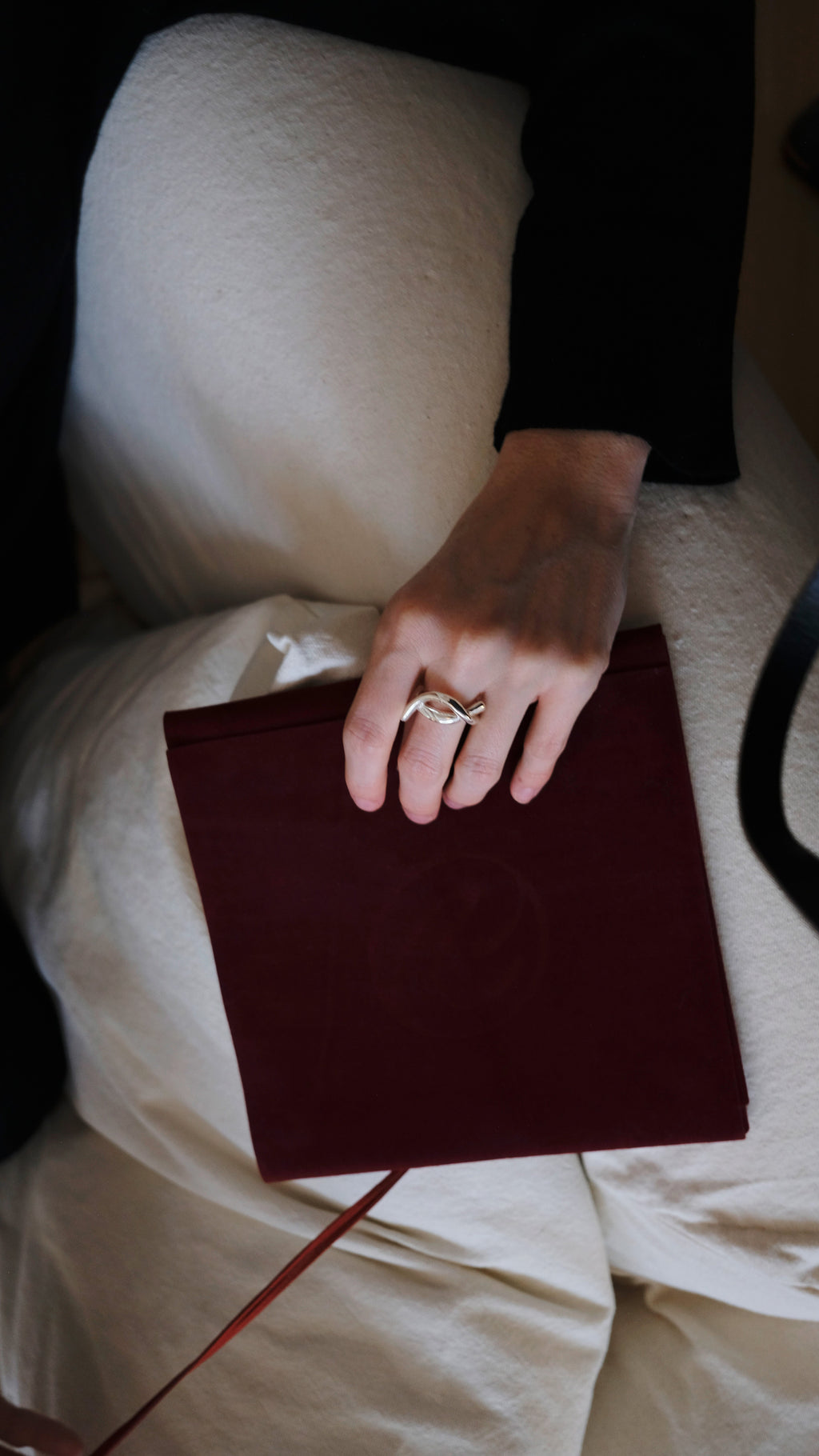 Hand with a silver ring holding a red packaging
