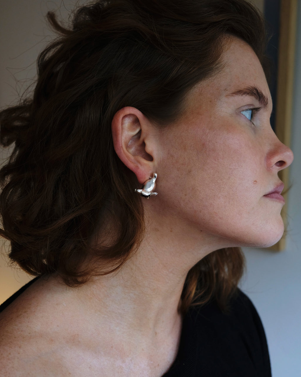 Woman wearing a silver earring with a blurred background
