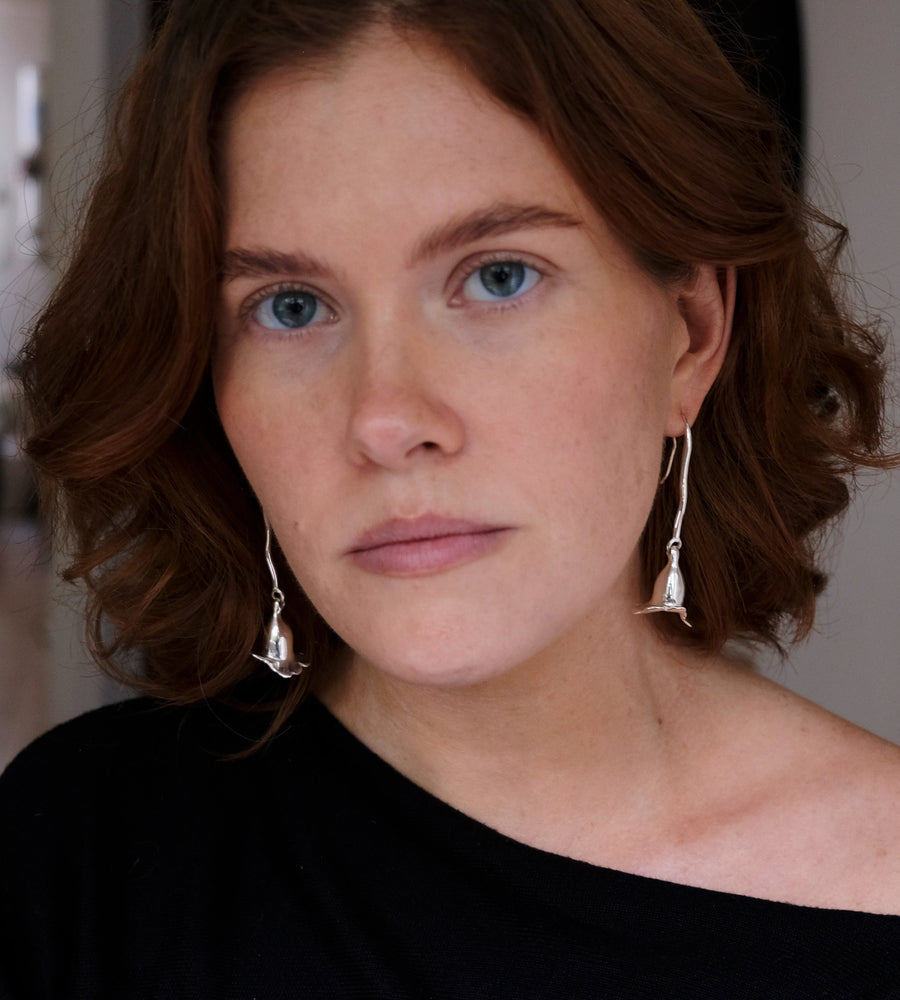 model wearing silver long floral earrings