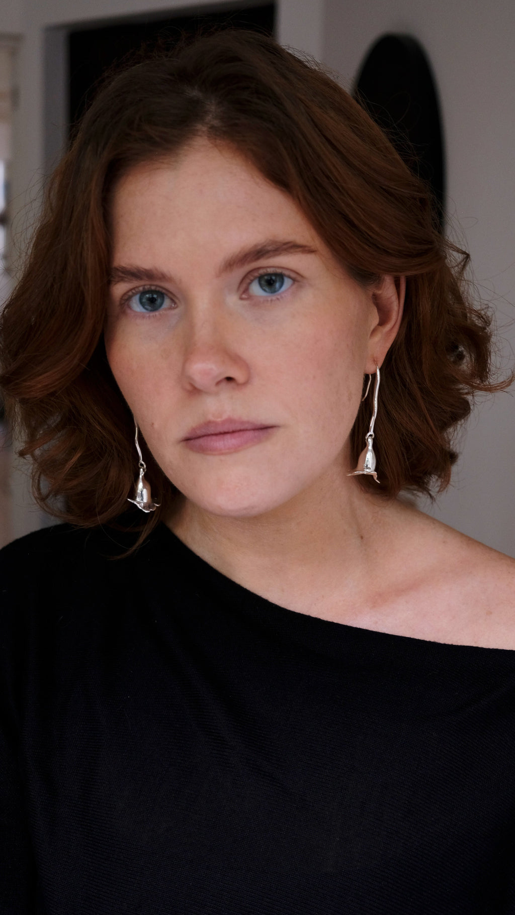 model wearing long sterling silver floral earrings