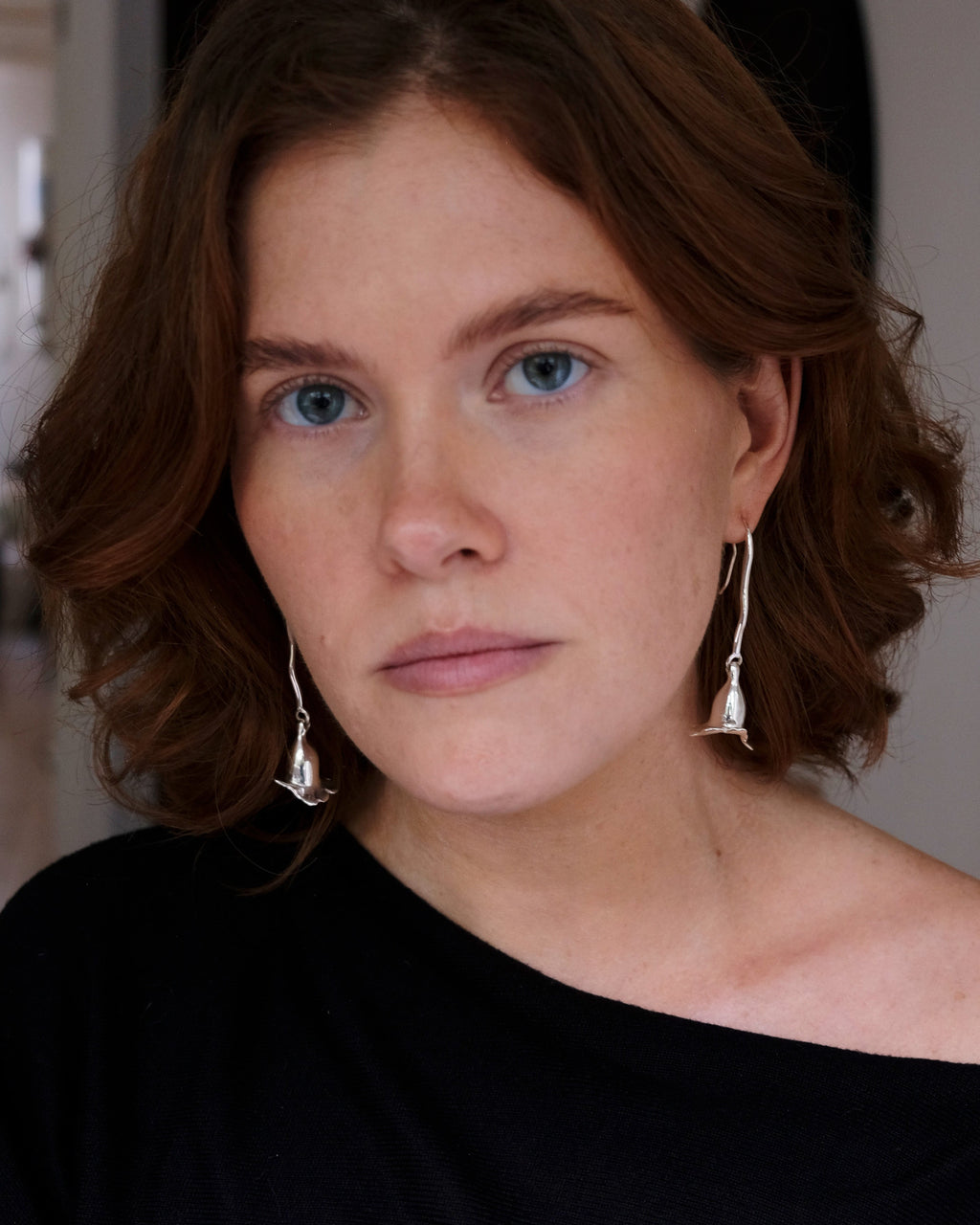 model wearing silver long floral earrings