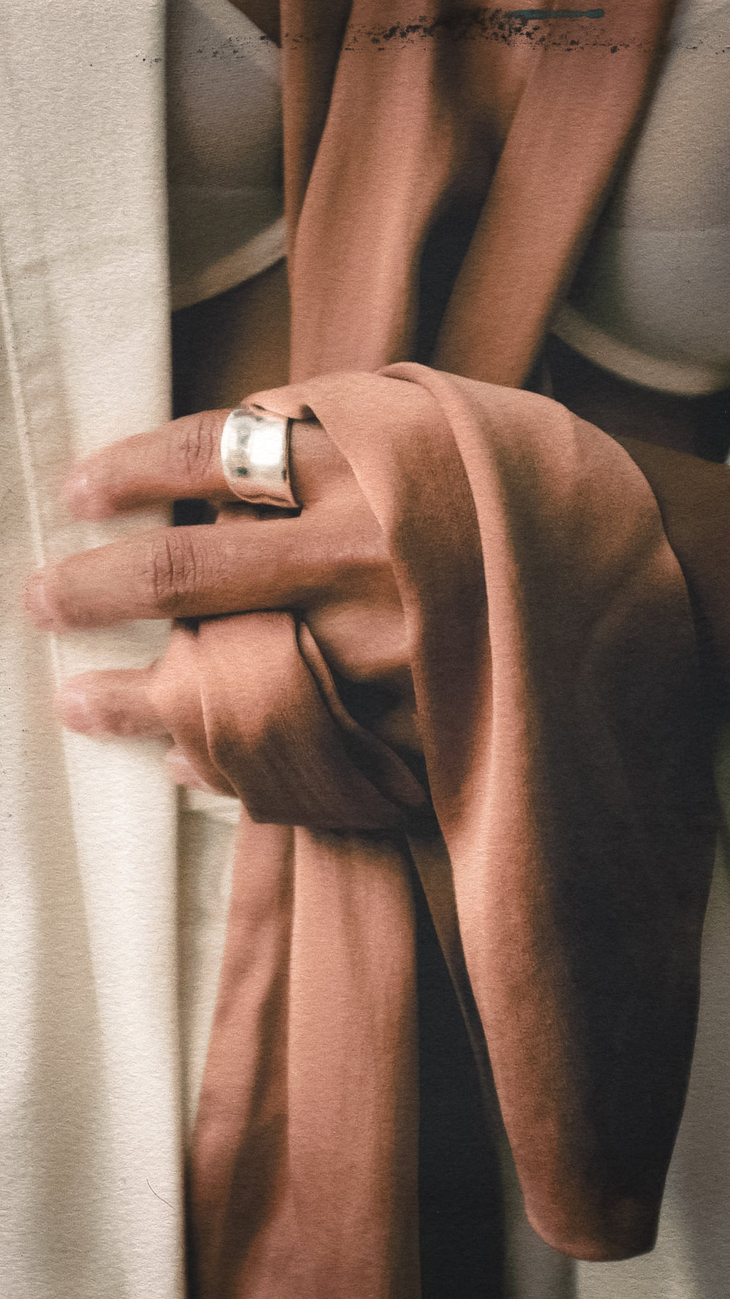 Close-up of a hand wearing a silver ring with a blurred background